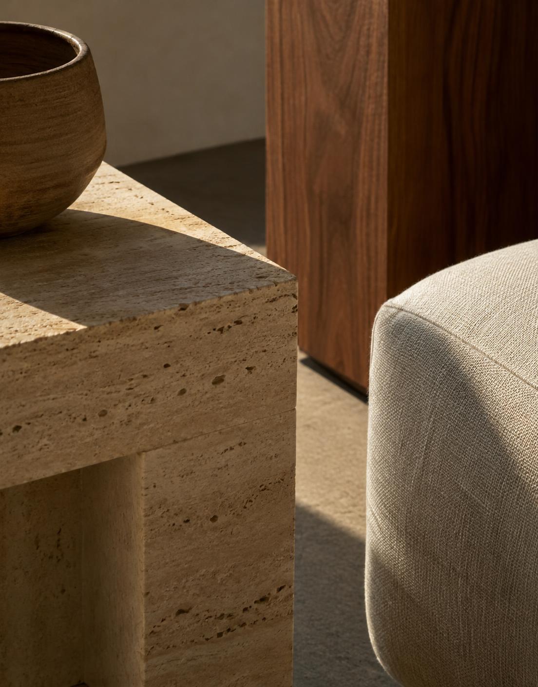 Close detail of travertine, walnut and linen in raking sunlight